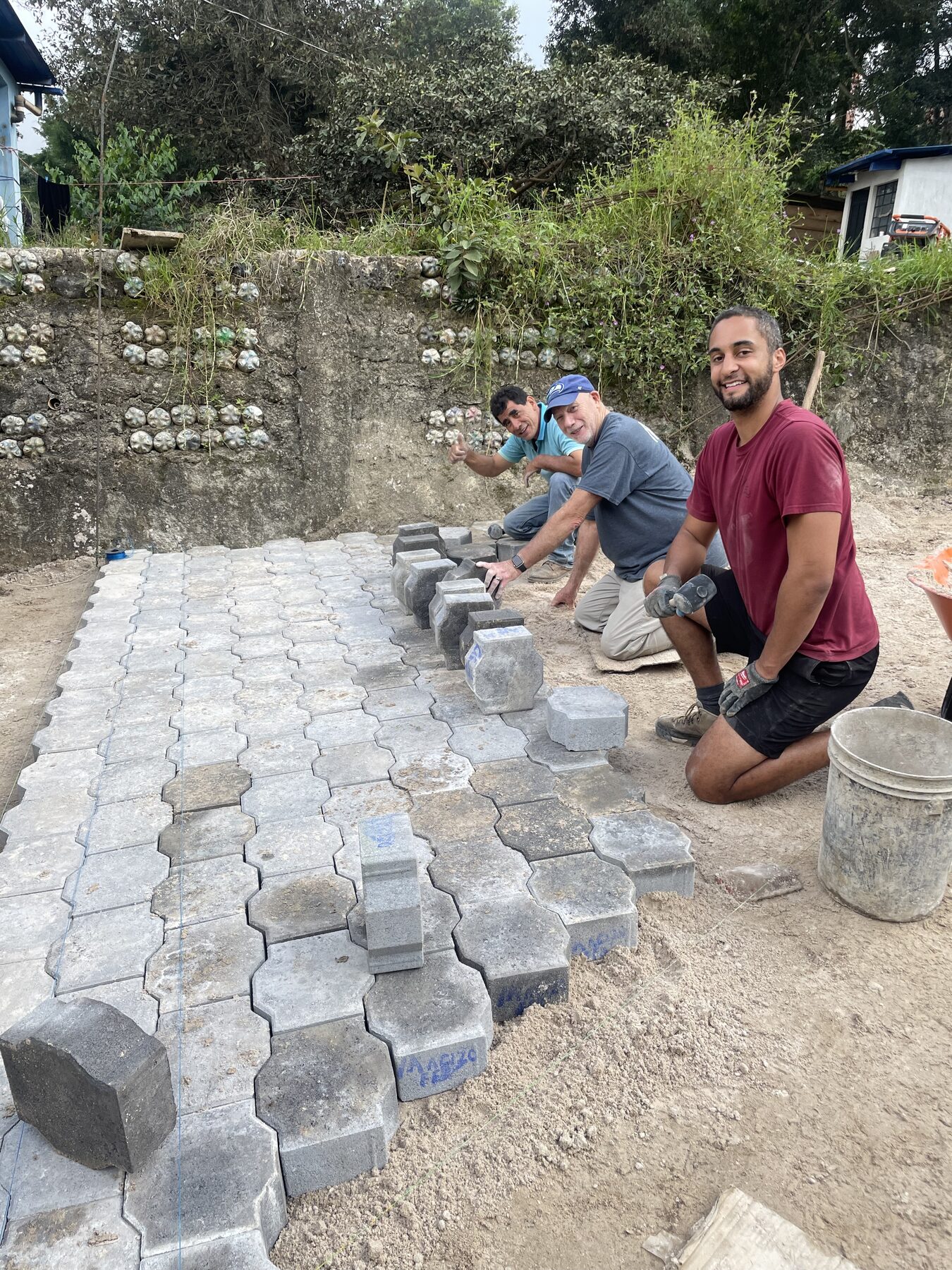 Men working together laying patio pavers